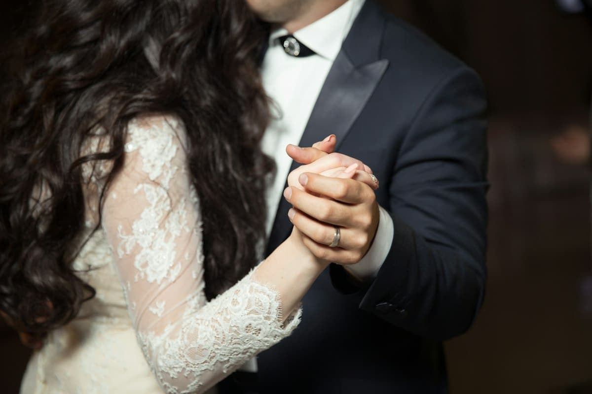 Las manos entrelazadas de los novios mientras bailan.